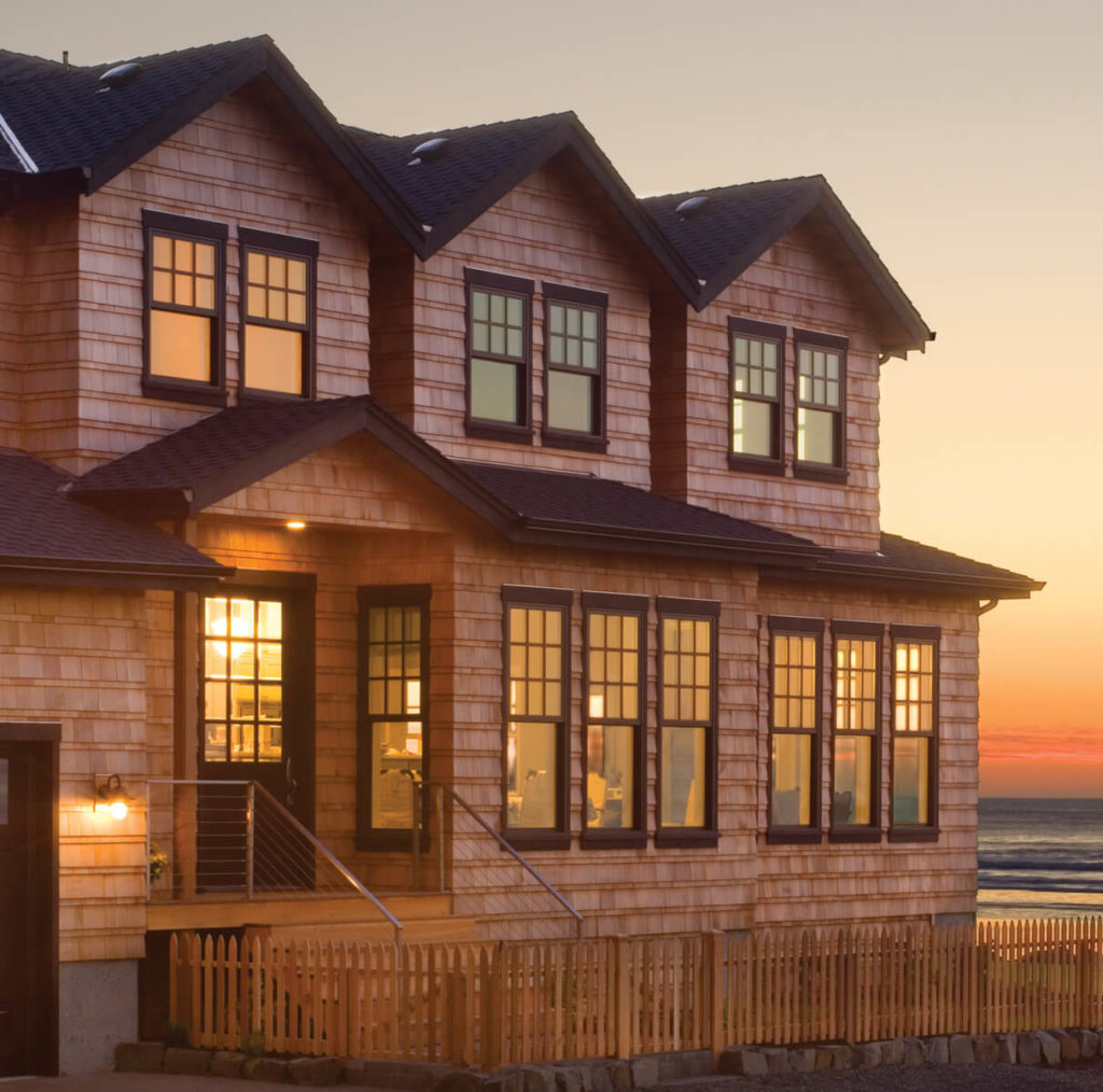 Beach house with multiple single hung windows and reflective glass