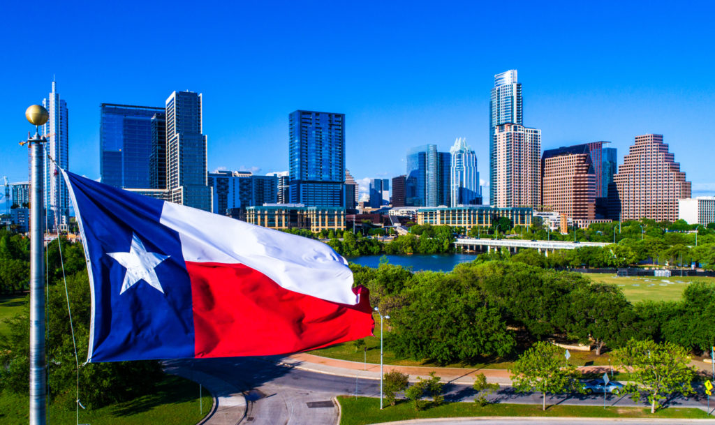 Perfect Texas flag flying in front of Austin Texas downtown skyline cityscape sunny perfect day